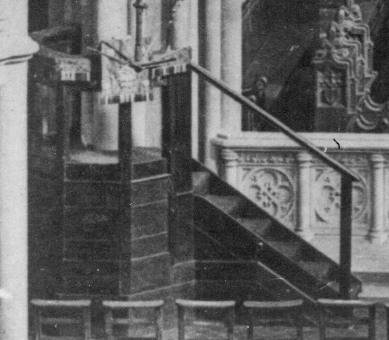 The first pulpit, a plain heavy octagonal structure of dark wood